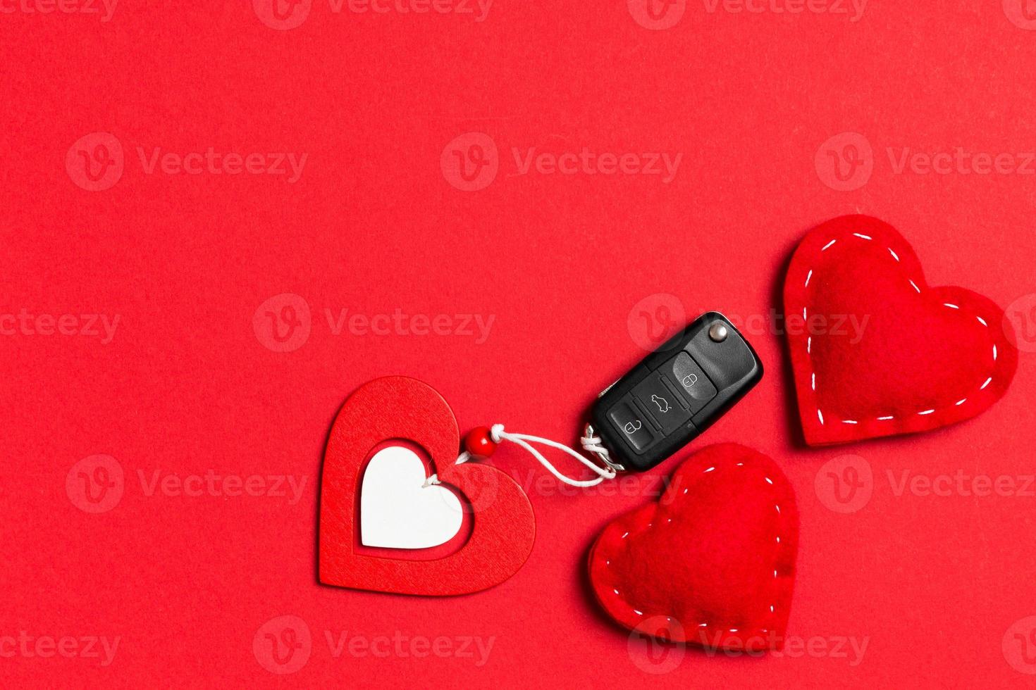 Top view of car key, wooden and textile heart on colorful background. Luxury present for Valentine's day photo