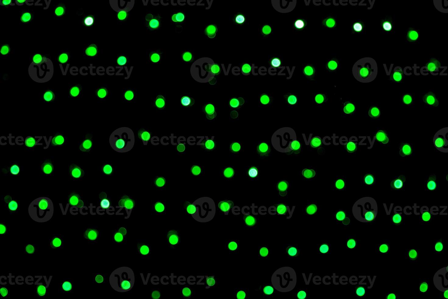 Unfocused abstract green bokeh on black background. defocused and blurred many round light photo