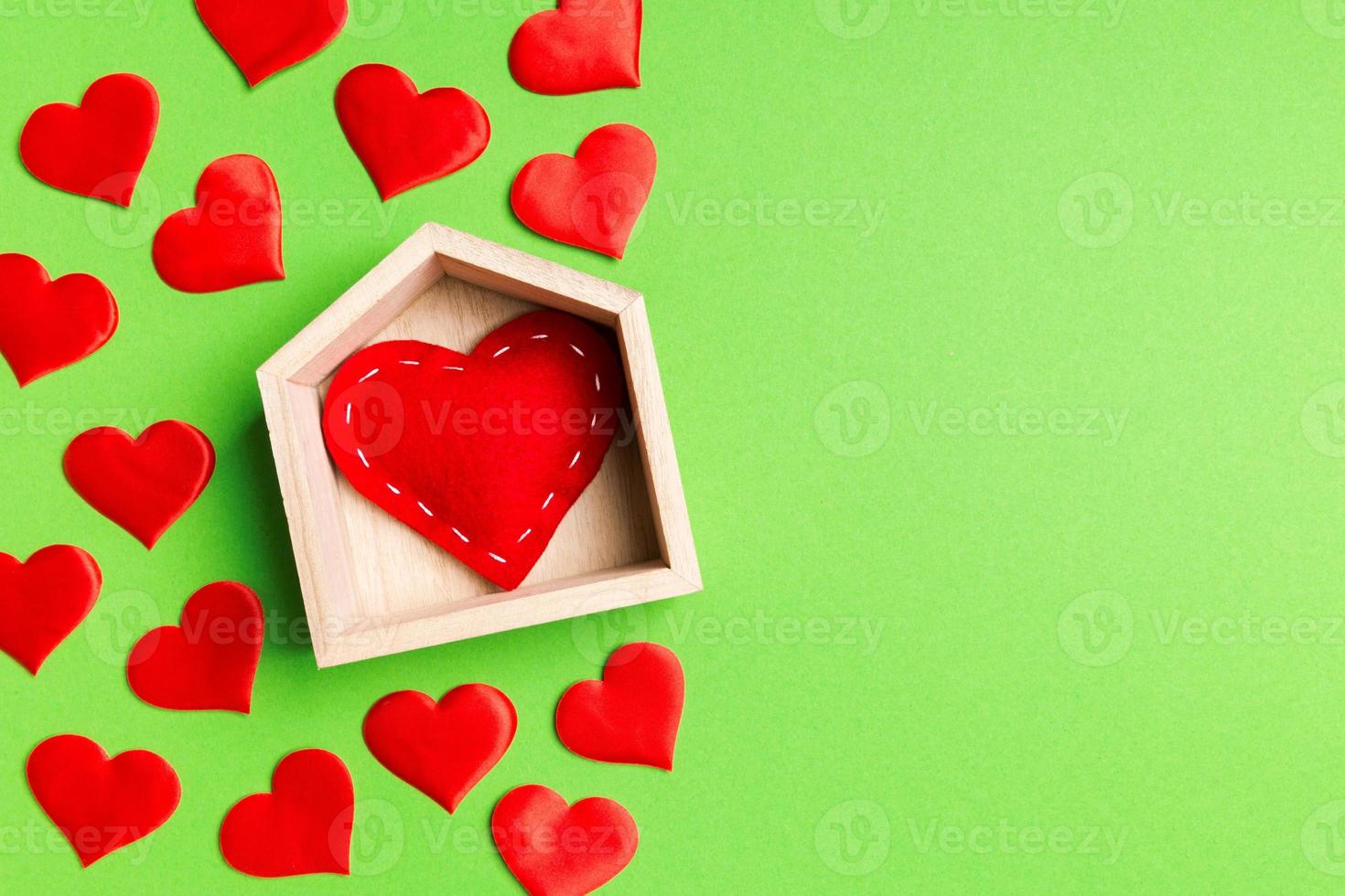 Top view composition made of red heart in a house surrounded with small hearts on colorful background. Home sweet home concept. Valentine's day photo