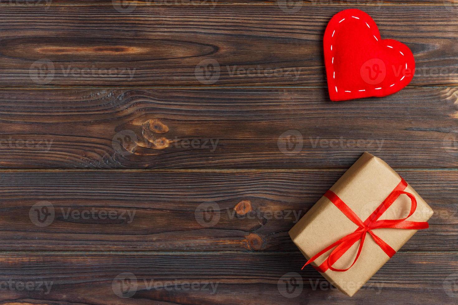 caja de regalo con corazones de tela sobre mesa de madera negra foto