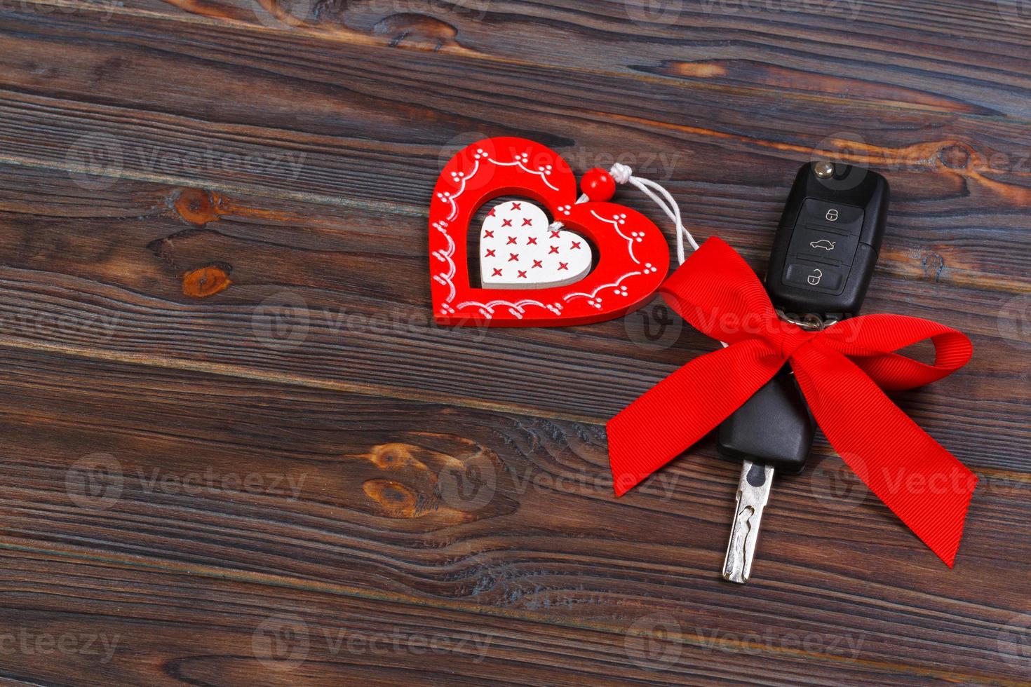 Car key with red heart on black natural background. Christmas or Valentine's Day gift or present abstract concept photo