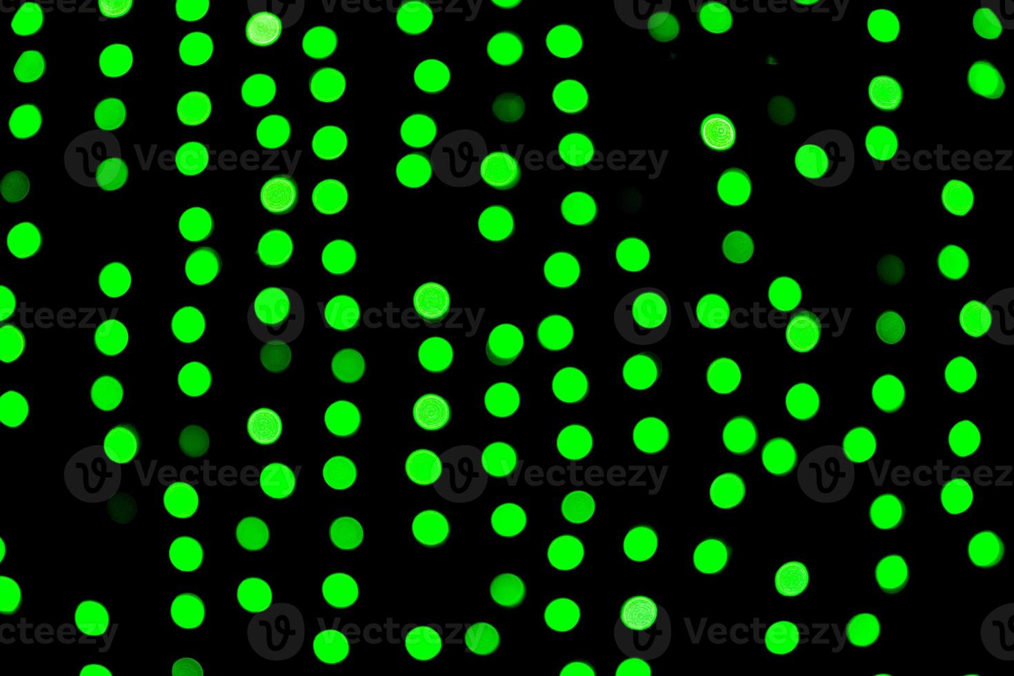Unfocused abstract green bokeh on black background. defocused and blurred many round light photo