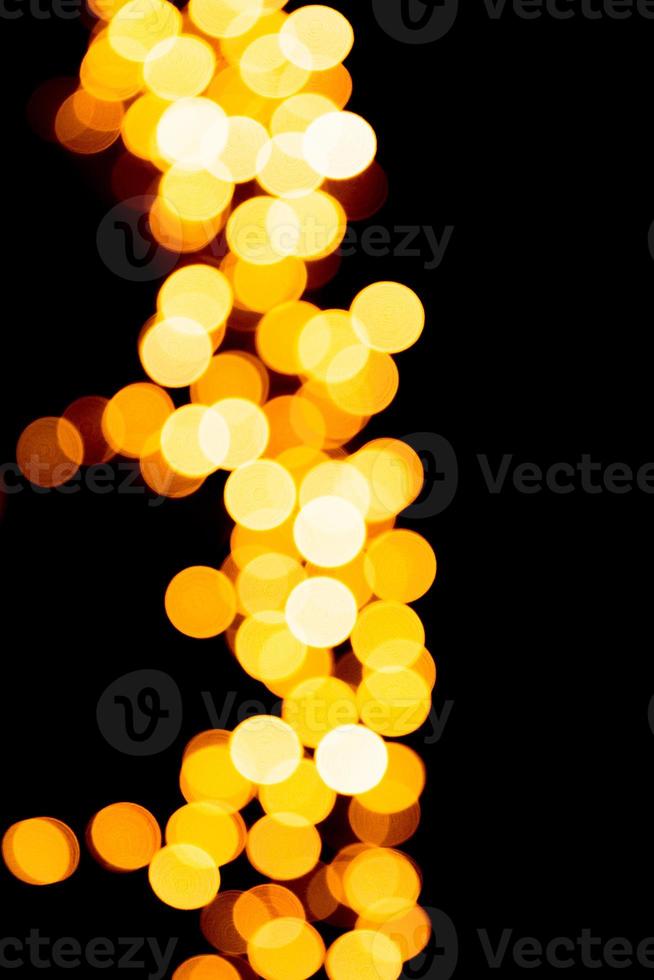 Defocused city gold night bokeh abstract background. blurred many round yellow light on dark background photo
