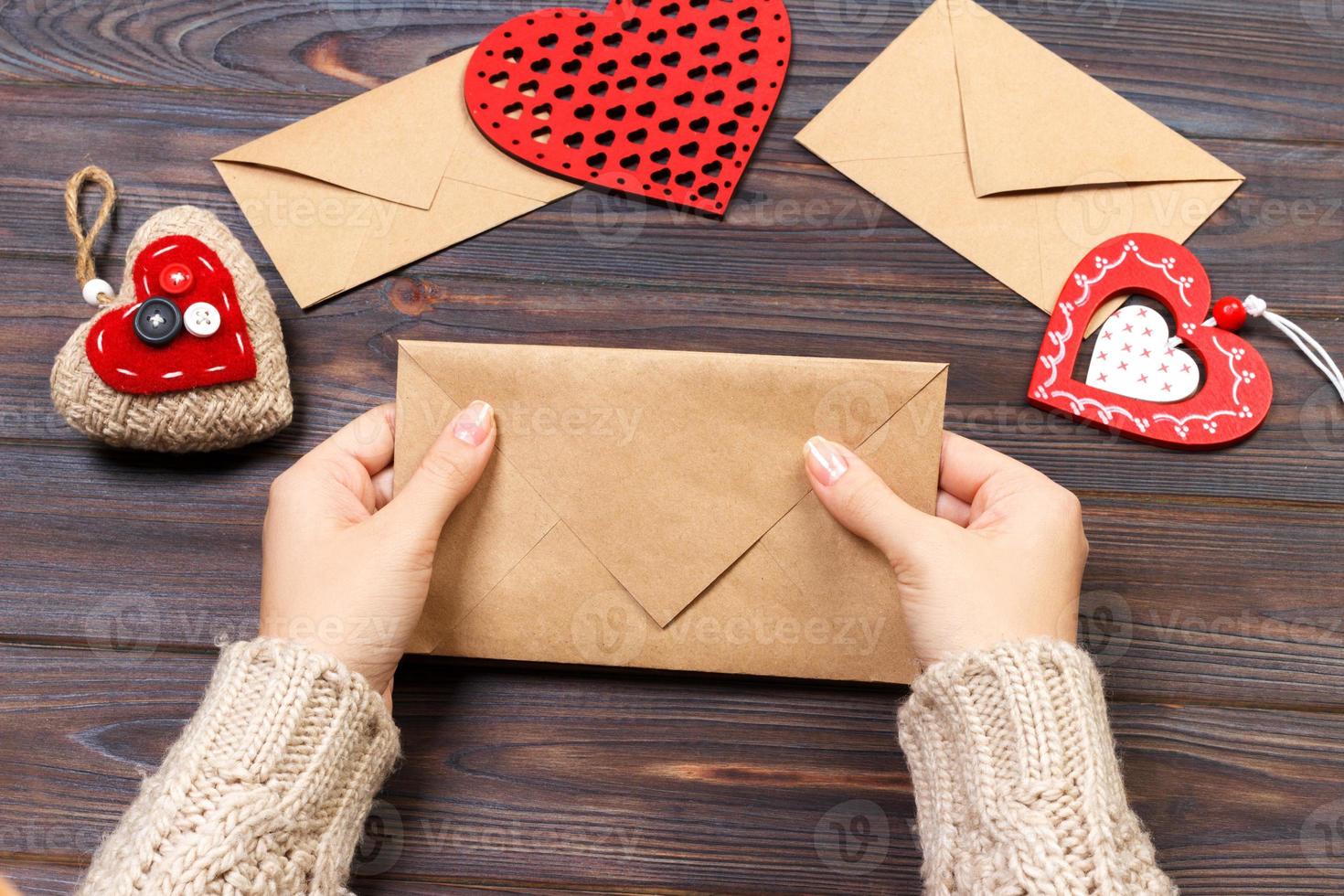 Woman preparing handmade envelope for wrapping on Valentine's Day. Valentine day concept with copyspace photo