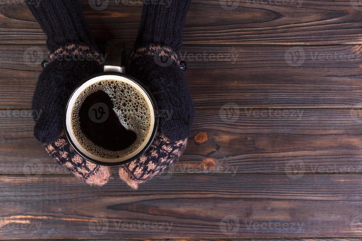 Girl in a warm clothes and mittens is holding white mug in hands. Mockup for winter gifts design, Merry Christmas and Happy New Year photo