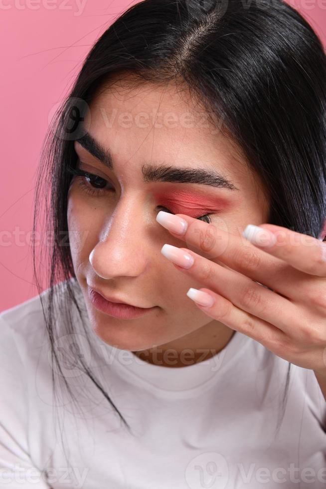 Woman doing make up, looking at mirror. photo