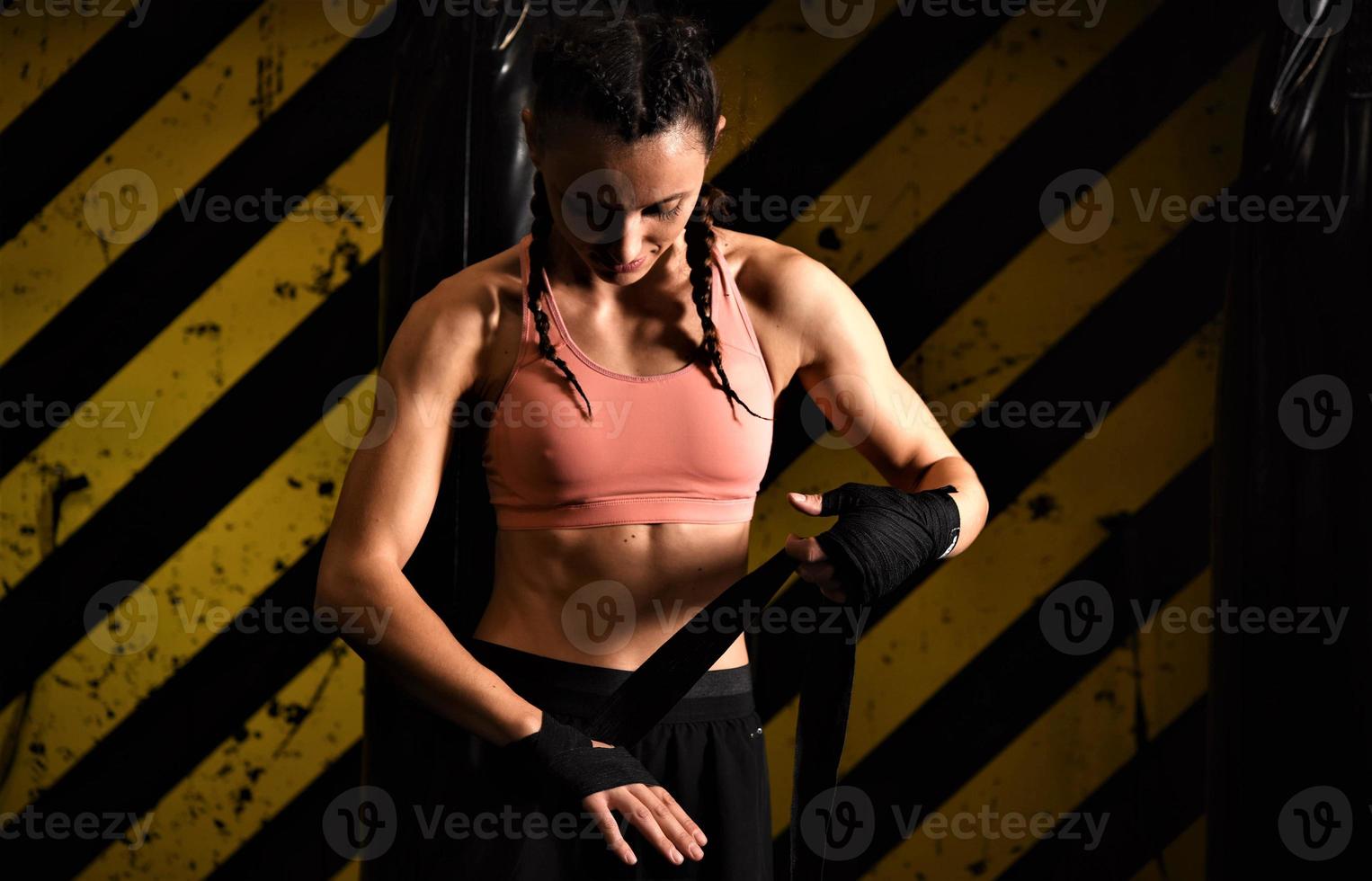 Close-up of a woman doing boxing bandages in a fighting cage photo