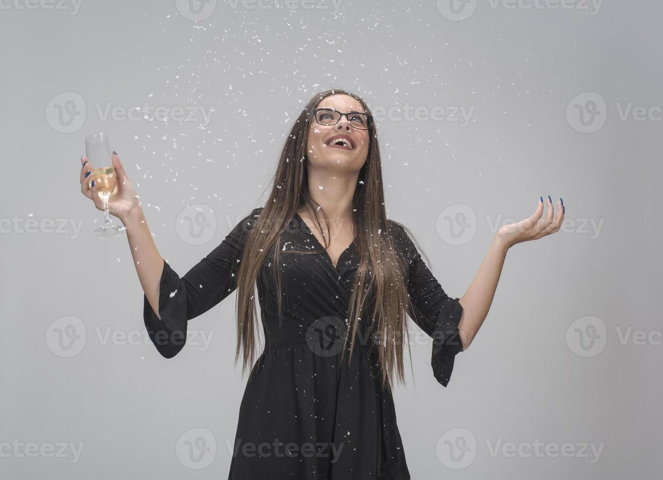 Beautiful woman celebrating New Year with confetti and champagne photo