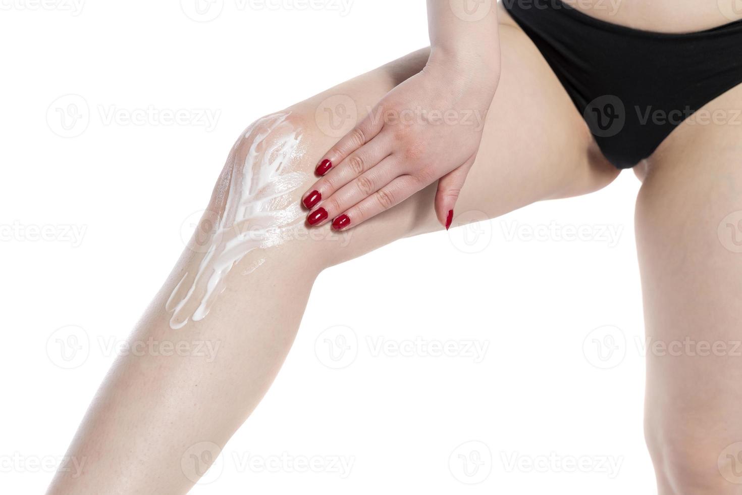 Woman Applying Cosmetic Foot Cream, Applying Cosmetic Cream after depilation, Skin Care. photo