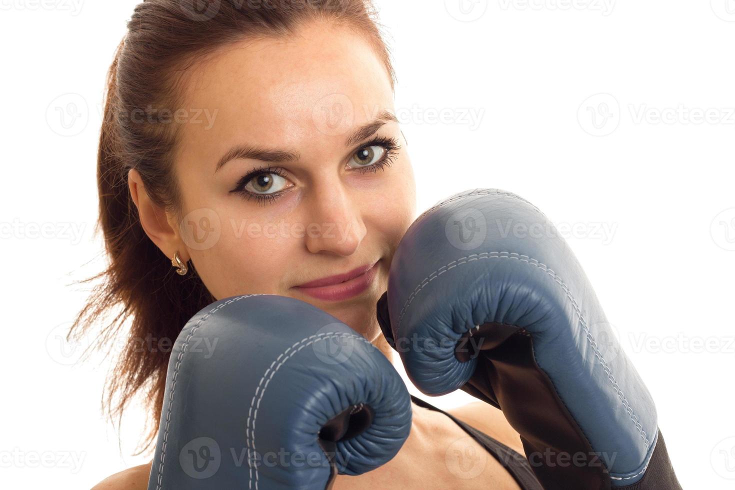 retrato de una joven que se mantiene cerca de la cara con las manos en el primer plano de los guantes de boxeo foto