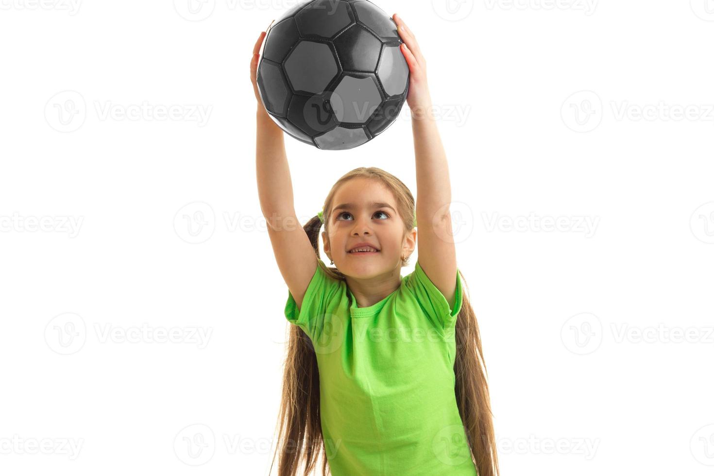 a cheerful little girl keeps a big ball in hands photo