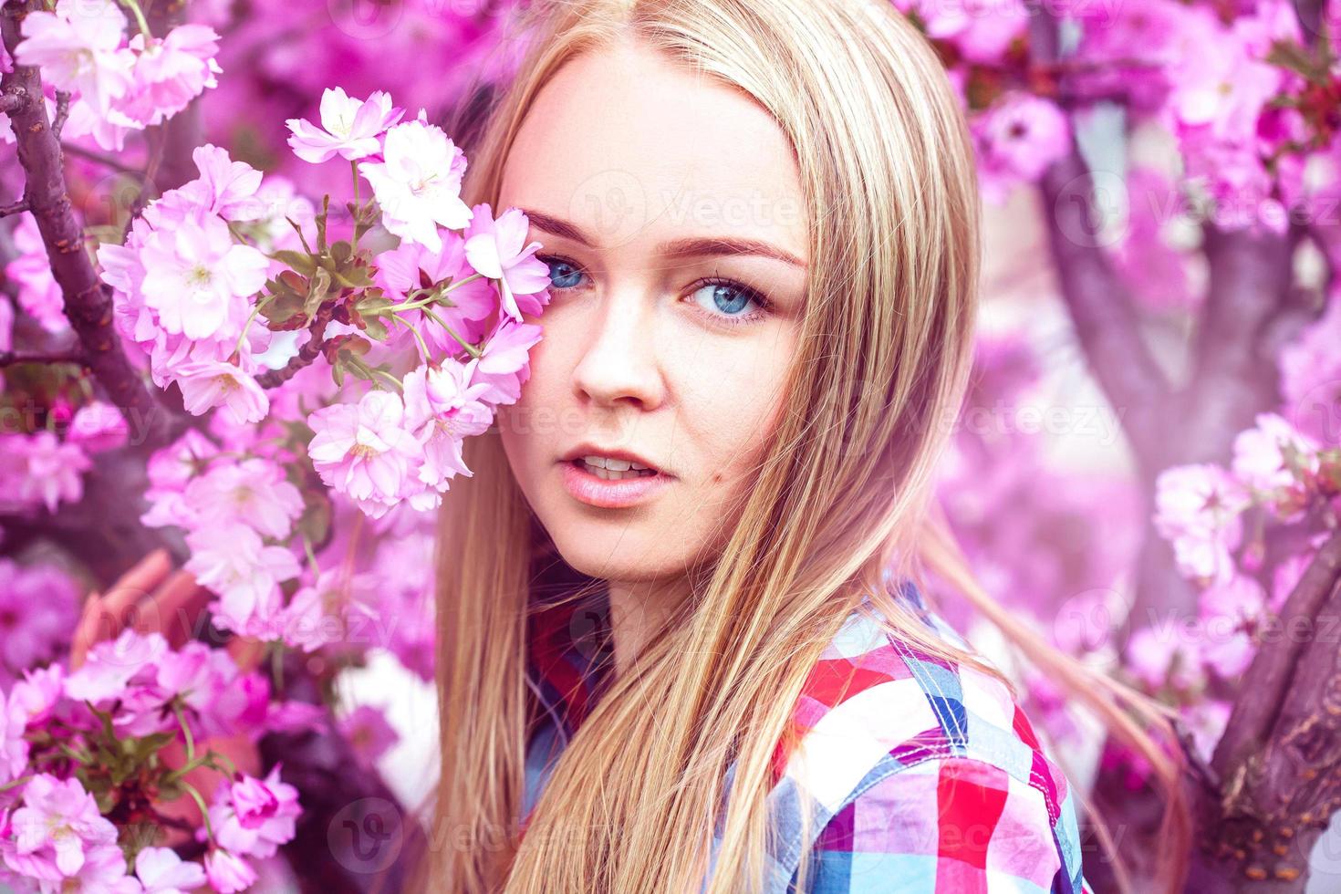 Young fashion model in pink blooming flowers photo