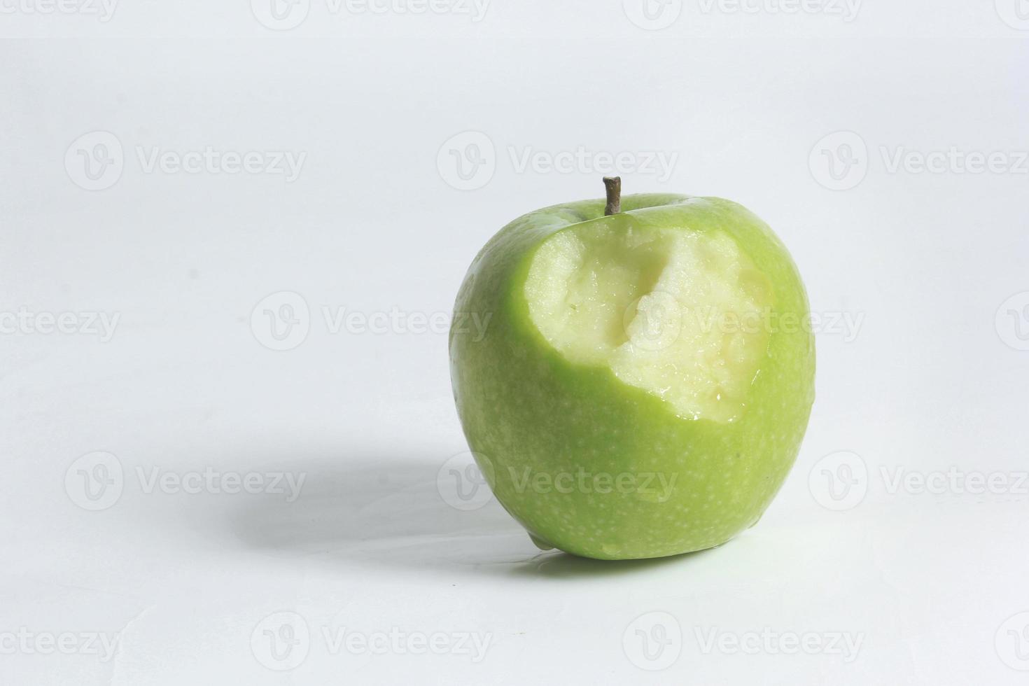 manzanas verdes frescas y marcas de mordeduras en un fondo blanco. foto