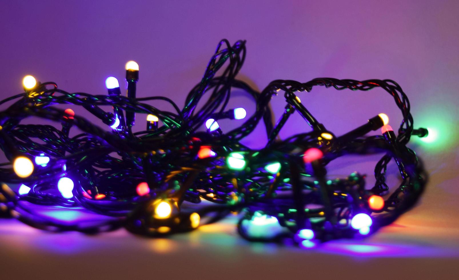 colorful tangled christmas lights on dark background photo