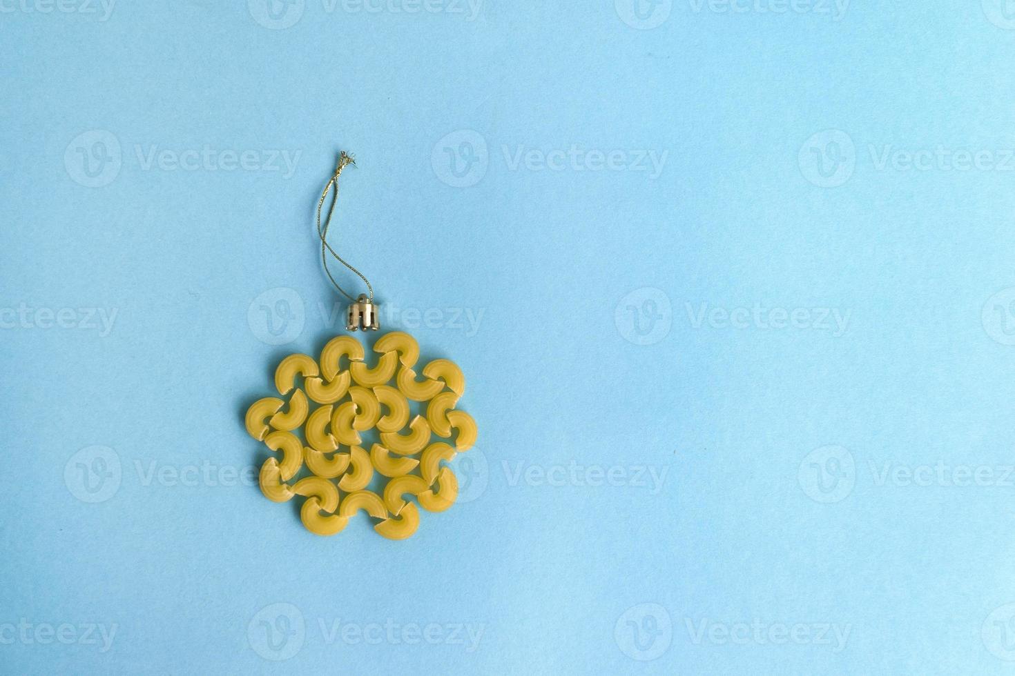 Christmas decoration ball made of pasta on a blue background photo