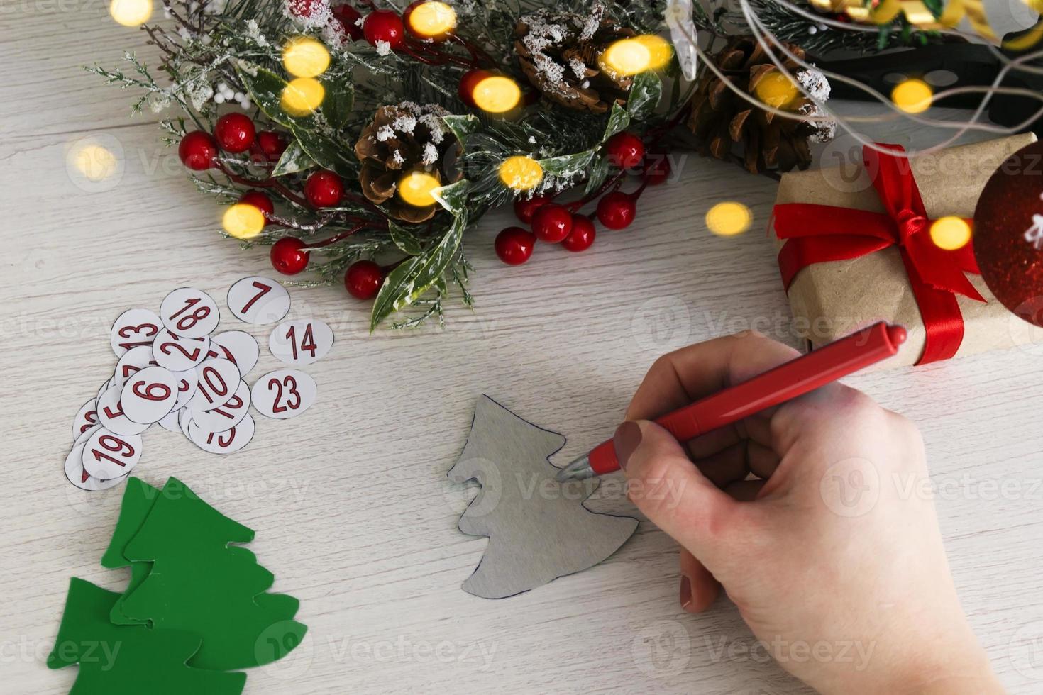 Advent calendar on wooden background with christmas tree branch and blur light. photo