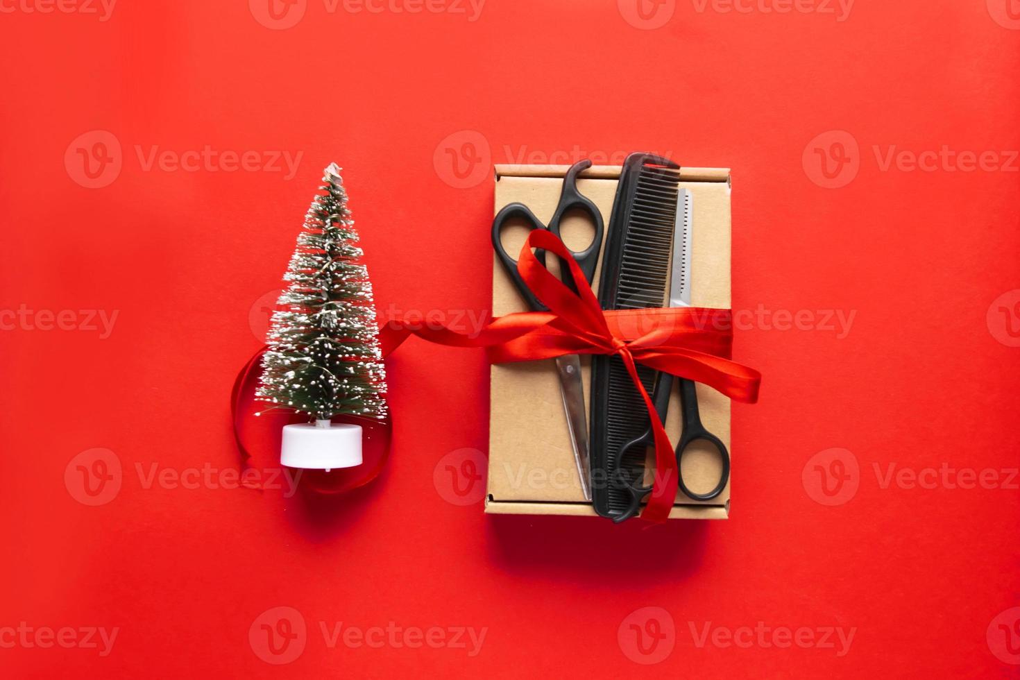 Flat lay Christmas composition. Hairdressing tools, gift and Christmas decor on a red background. Xmas, happy new year photo