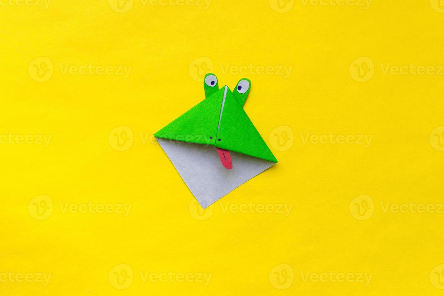 Step by step photo instruction how to make origami paper bookmark frog. Simple diy with kids children's concept.