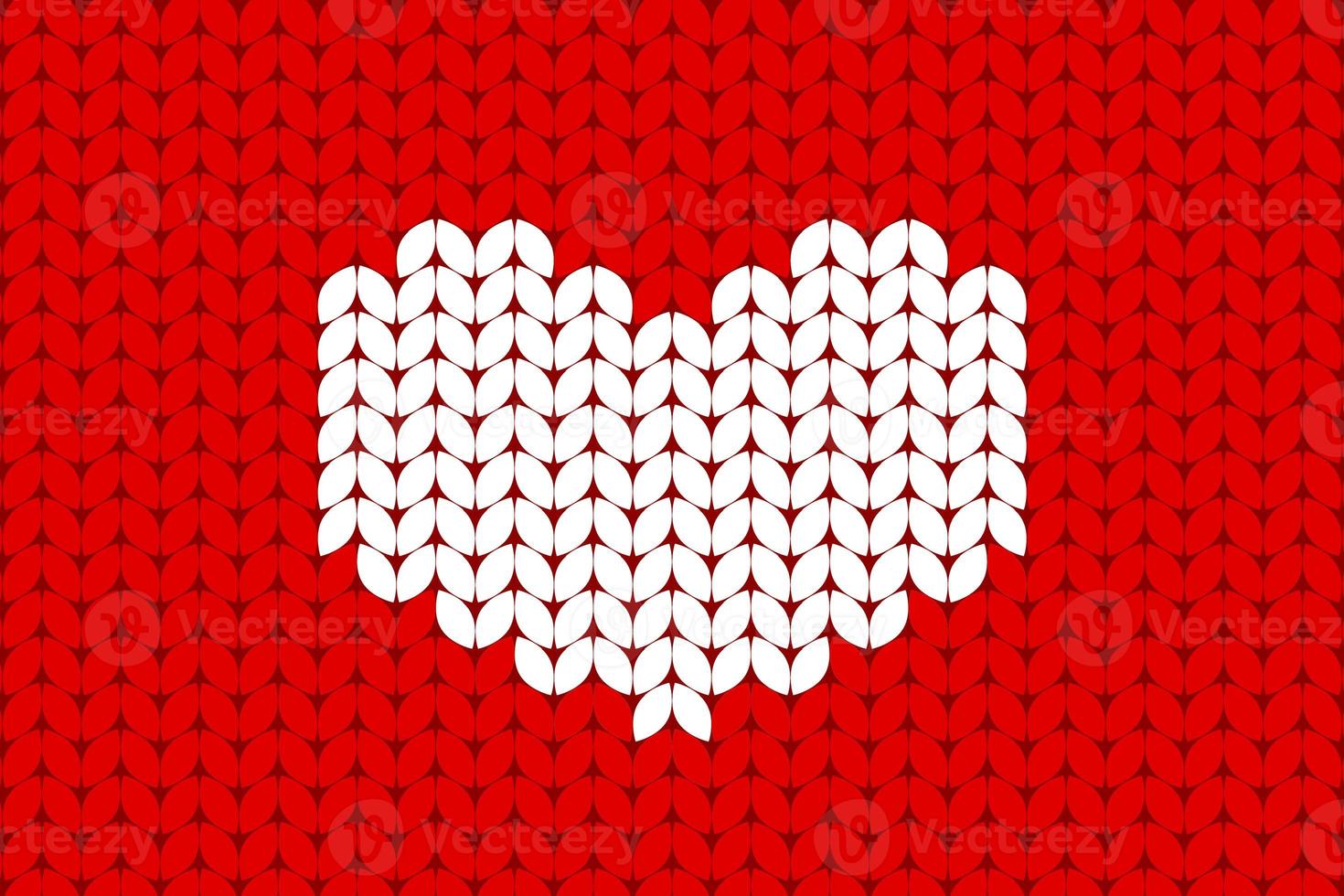 White knitted heart on red background. Valentines day background in a wool knitted pattern photo
