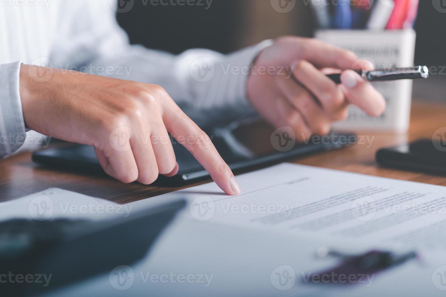 Businessman pointing at document and handing pen to client,Management of business documents and agreements, signing of business contracts, approval of contract documents or warranty certificates. photo