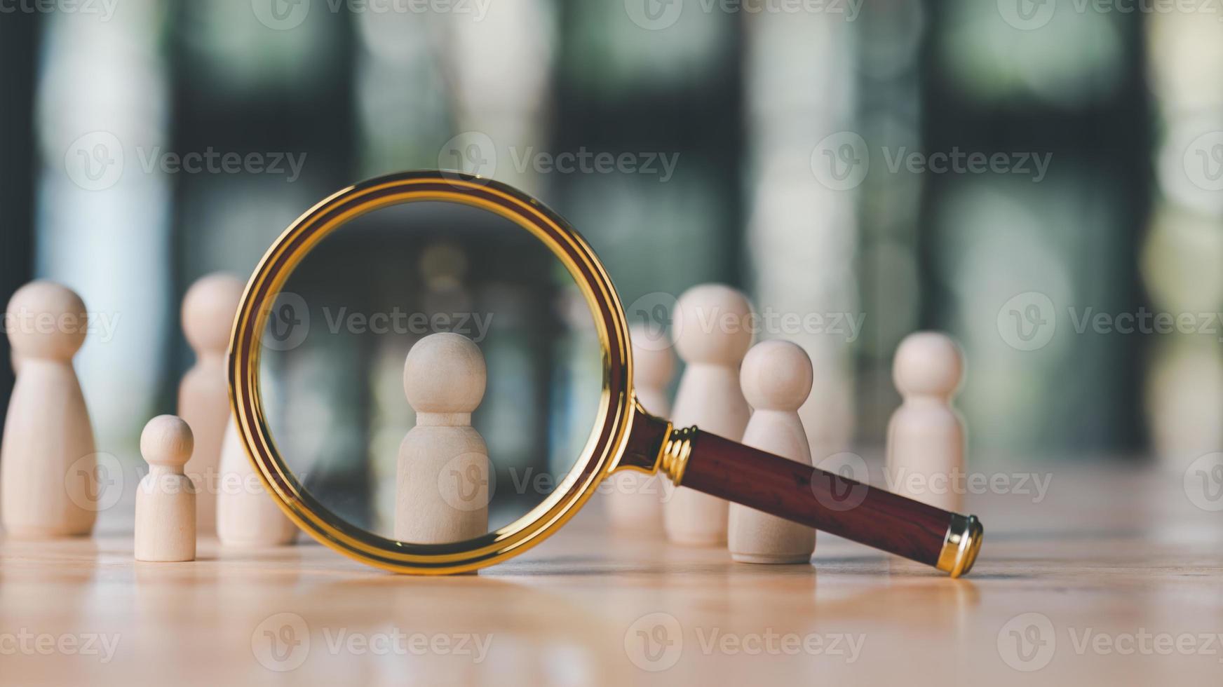 magnifying glass and a wooden doll are placed on table,HRM or Human Resource Management,leadership in recruitment,Business development by choosing professional leaders employee competency teamwork photo