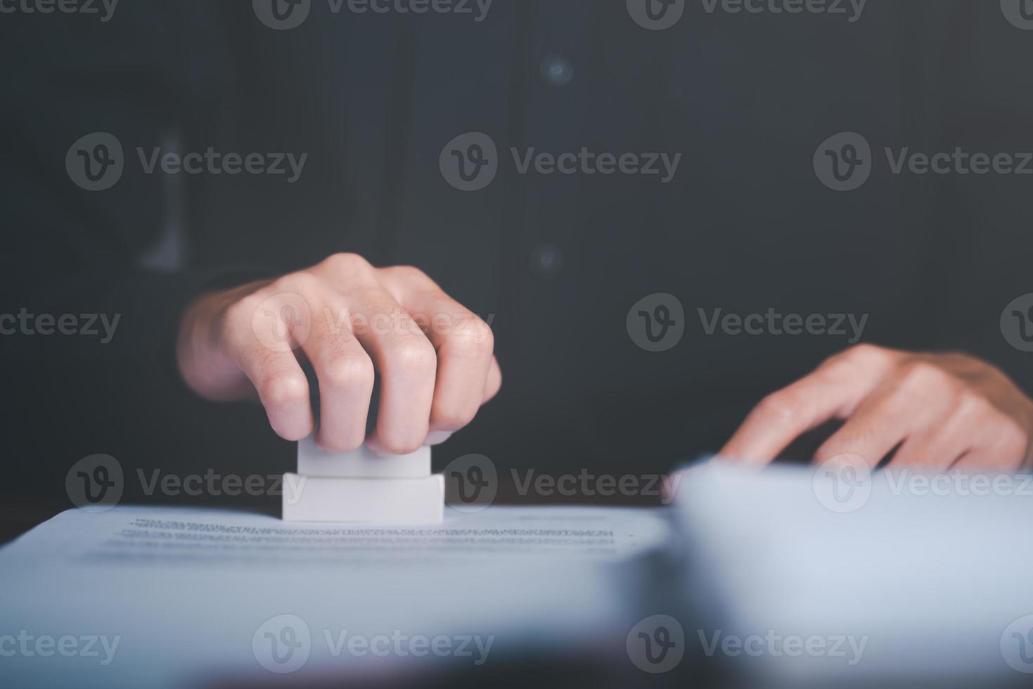 Businessman validates and manages business documents and agreements, signing a business contract approval of contract documents confirmation or warranty certificate,approval stamp photo
