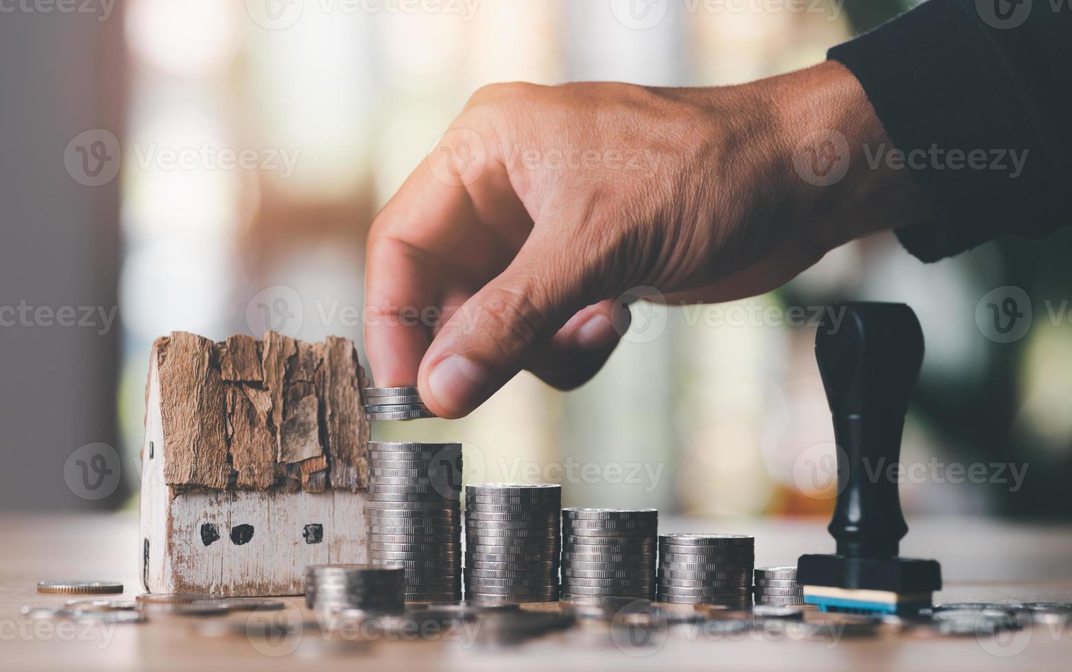 mano masculina apilando dinero en pilas de monedas, concepto de aprobación de préstamos de inversión para la construcción de viviendas, negocios inmobiliarios, ahorros de inversión, préstamos hipotecarios y bancarios, planificación de jubilación futura foto