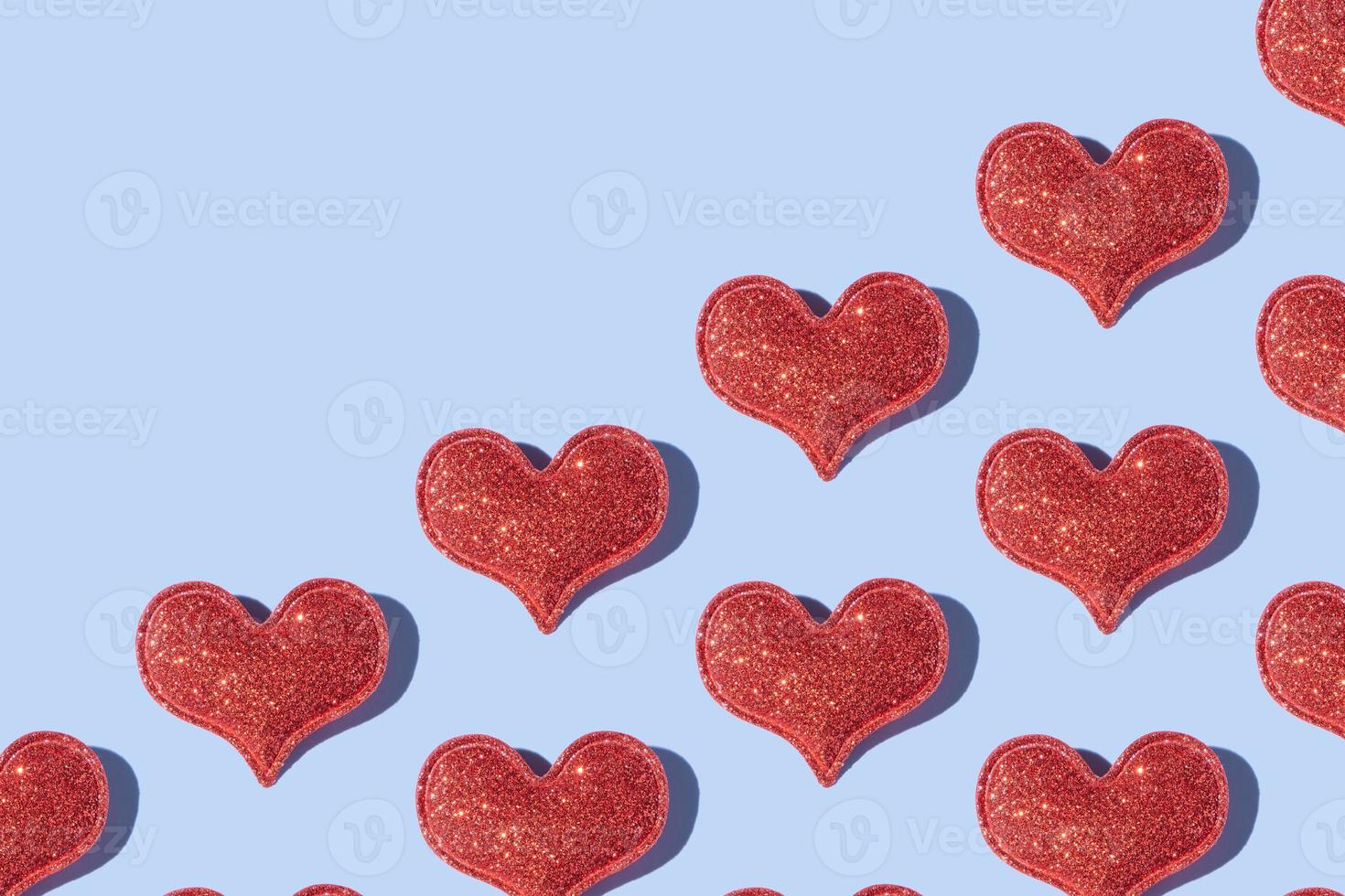 Pattern made from glitter heart shape on colored background with hard shadow. Valentines day minimalistic design photo