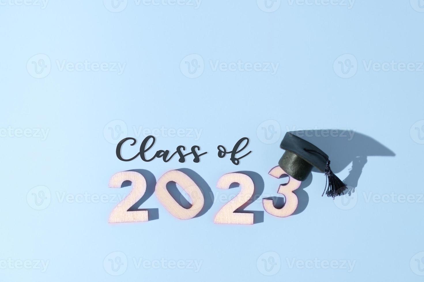 Class of 2023 concept. Numbers 2023 with black graduated cap on colored background photo