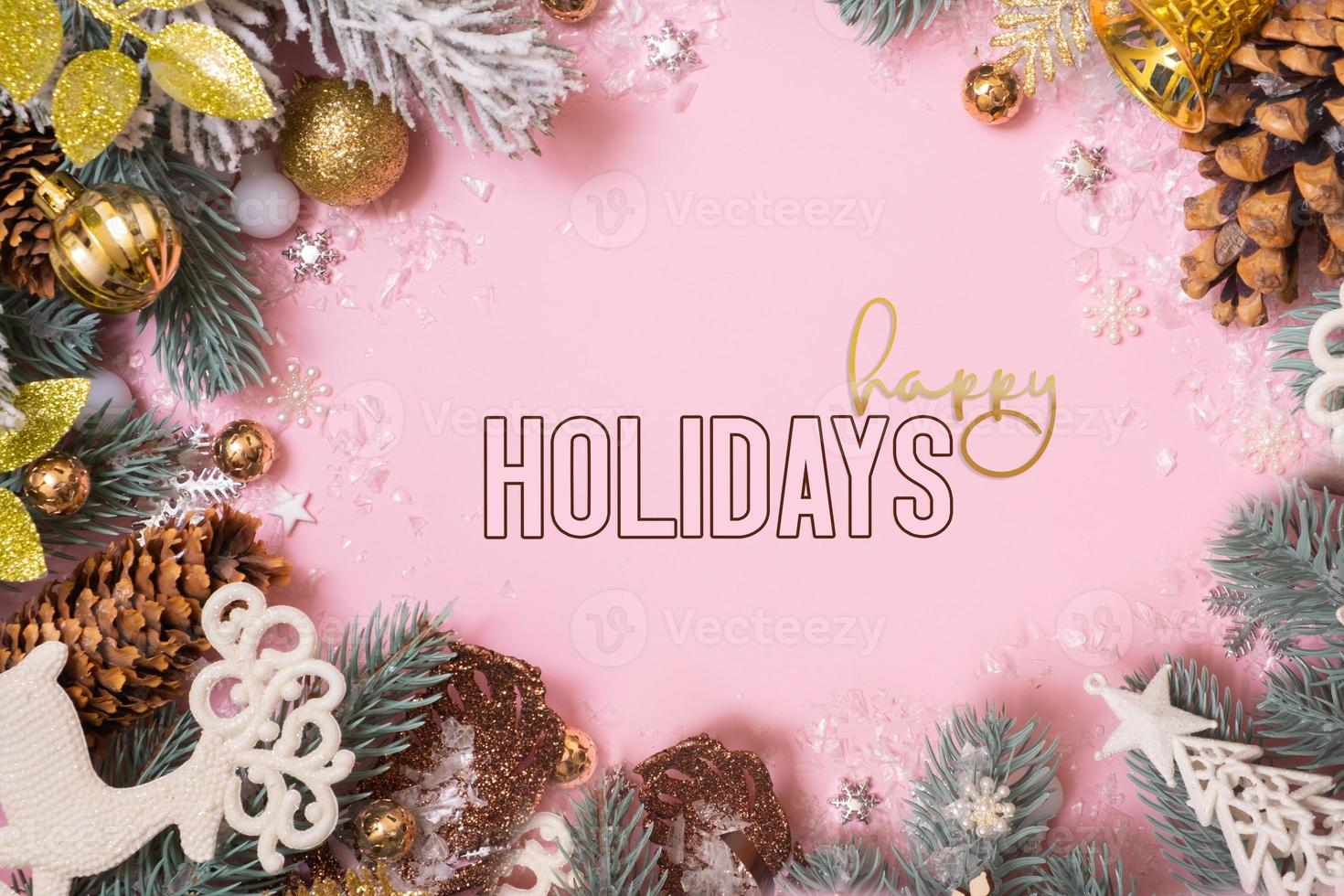 Happy Holidays greeting text with Christmas decoration on pink background. New Year Xmas greeting card photo