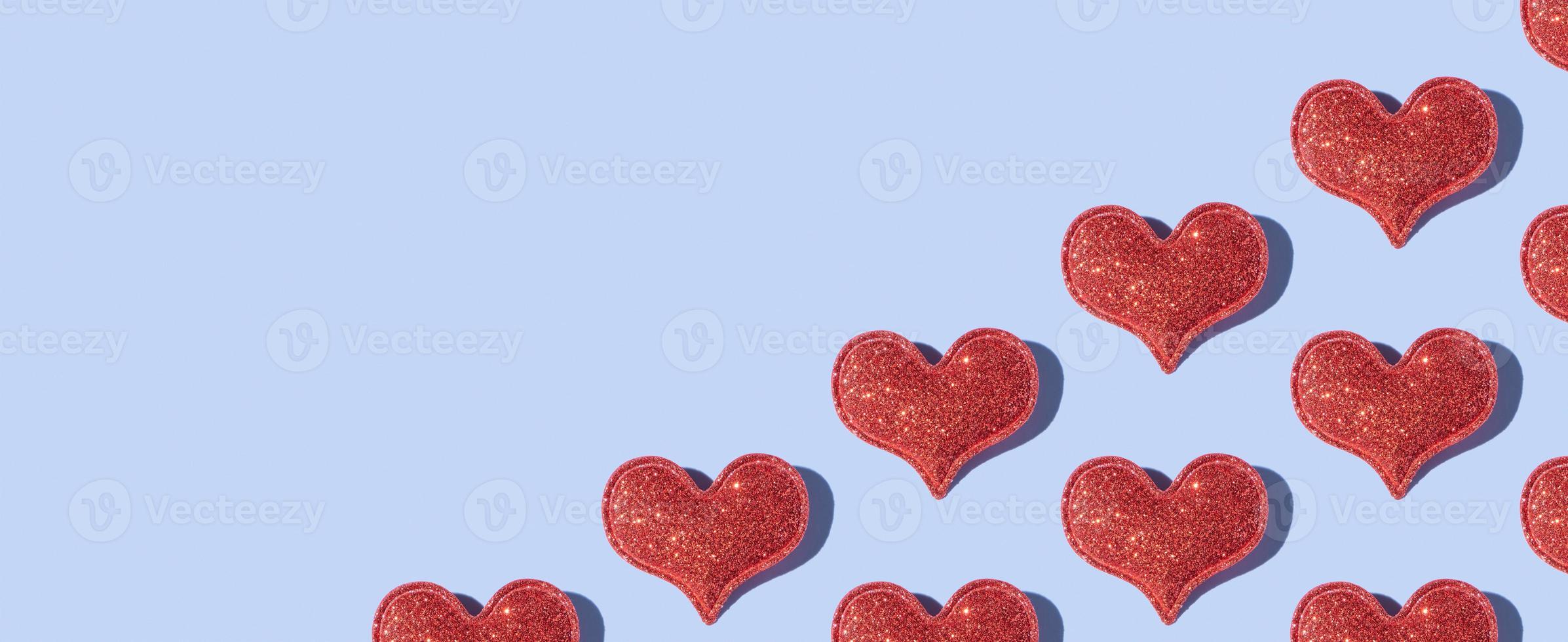 Banner from pattern made from glitter heart shape on colored background with hard shadow. Valentines day minimalistic design photo