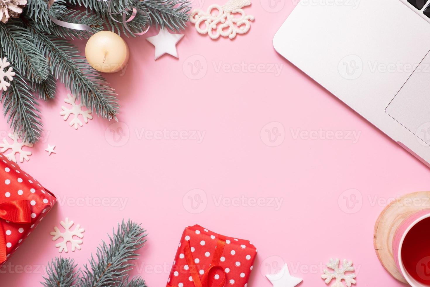 Office work table with Cristmas and New Year decoration top view, flat lay on pink background. Copy space for text during winter holidays photo