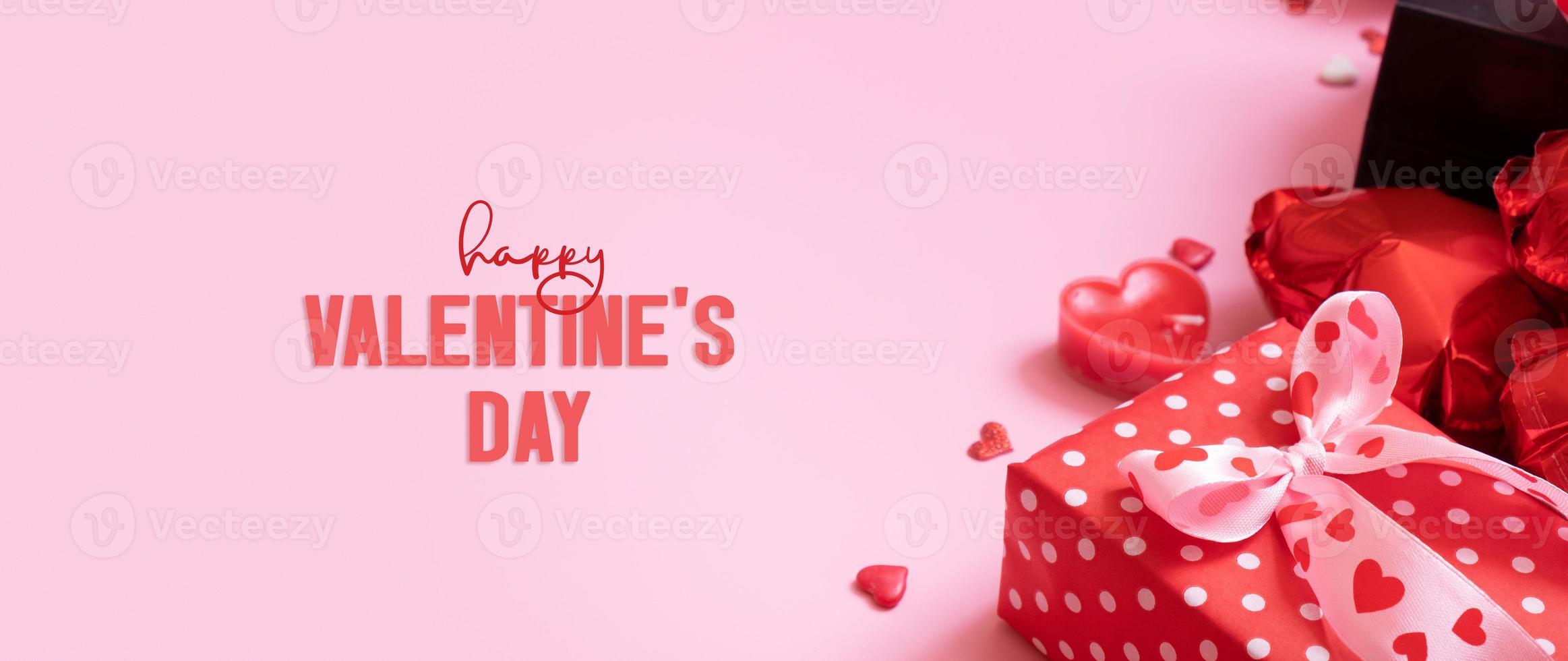 Happy Valentines Day text and gift box with red candels on pink background. Valentines Day greeting card photo