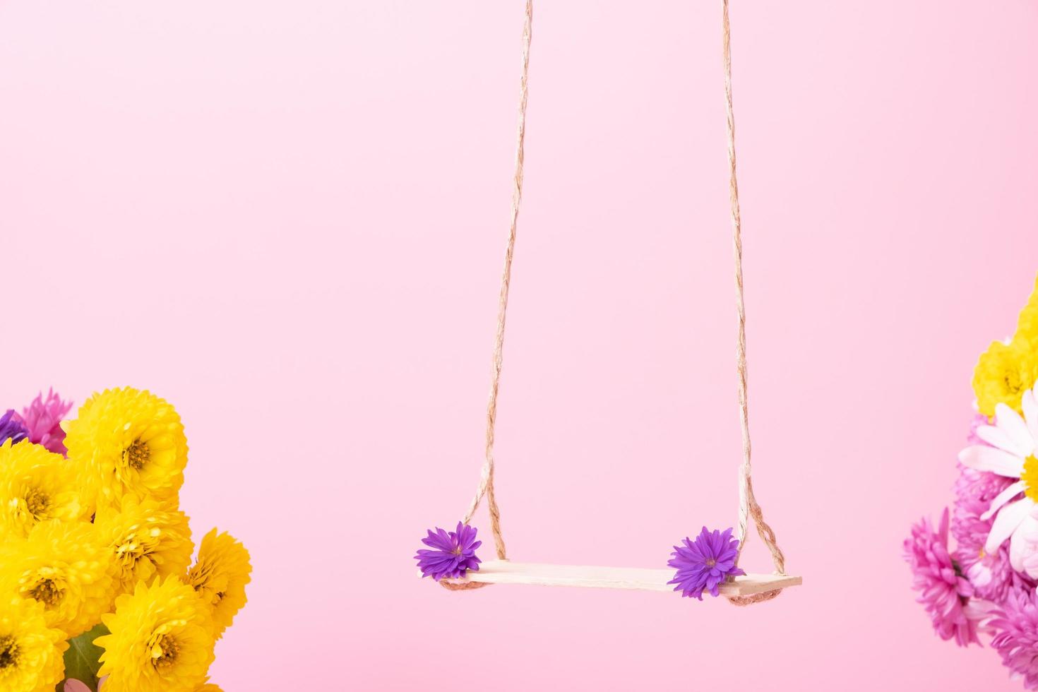 A swing with chrysanthemum flowers as a stand for your cosmetic product photo