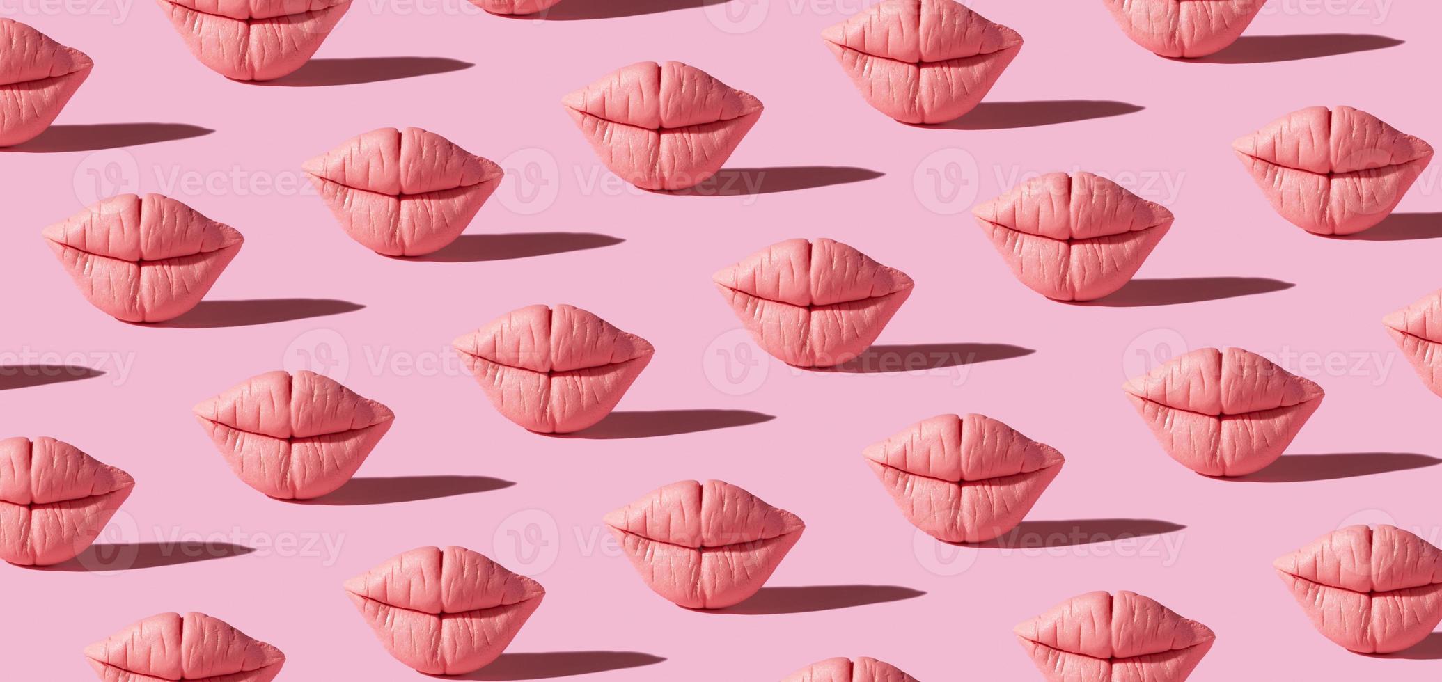 Banner with pattern from pink lips on pink background. Creative beauty concept background photo