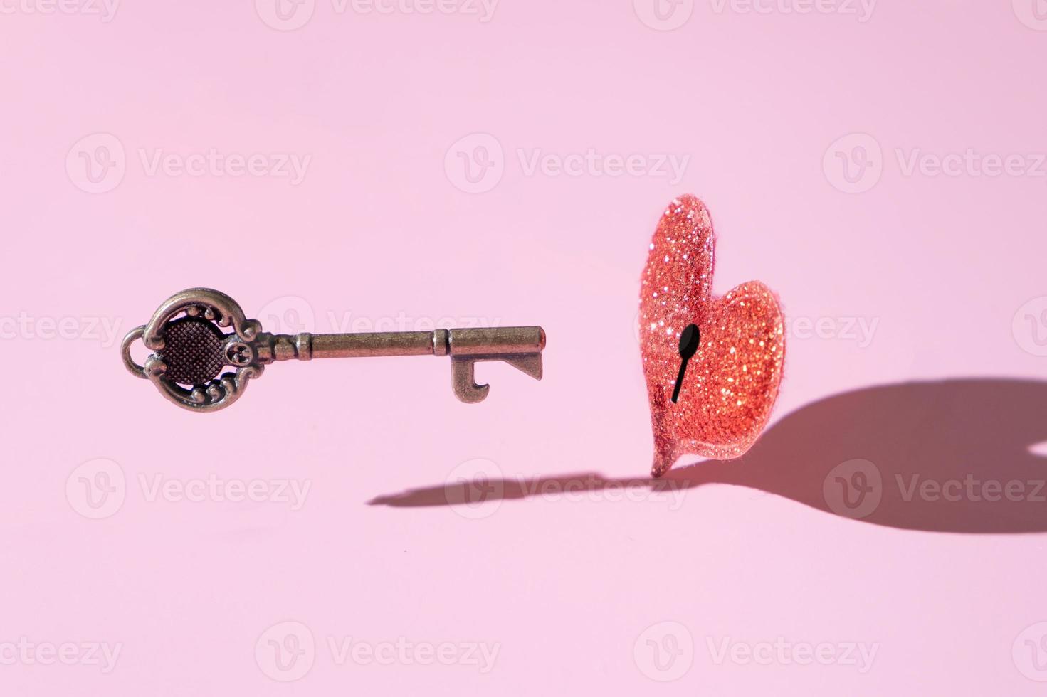 Vintage Key for opening red glitter heart. Love concept creative photo. photo