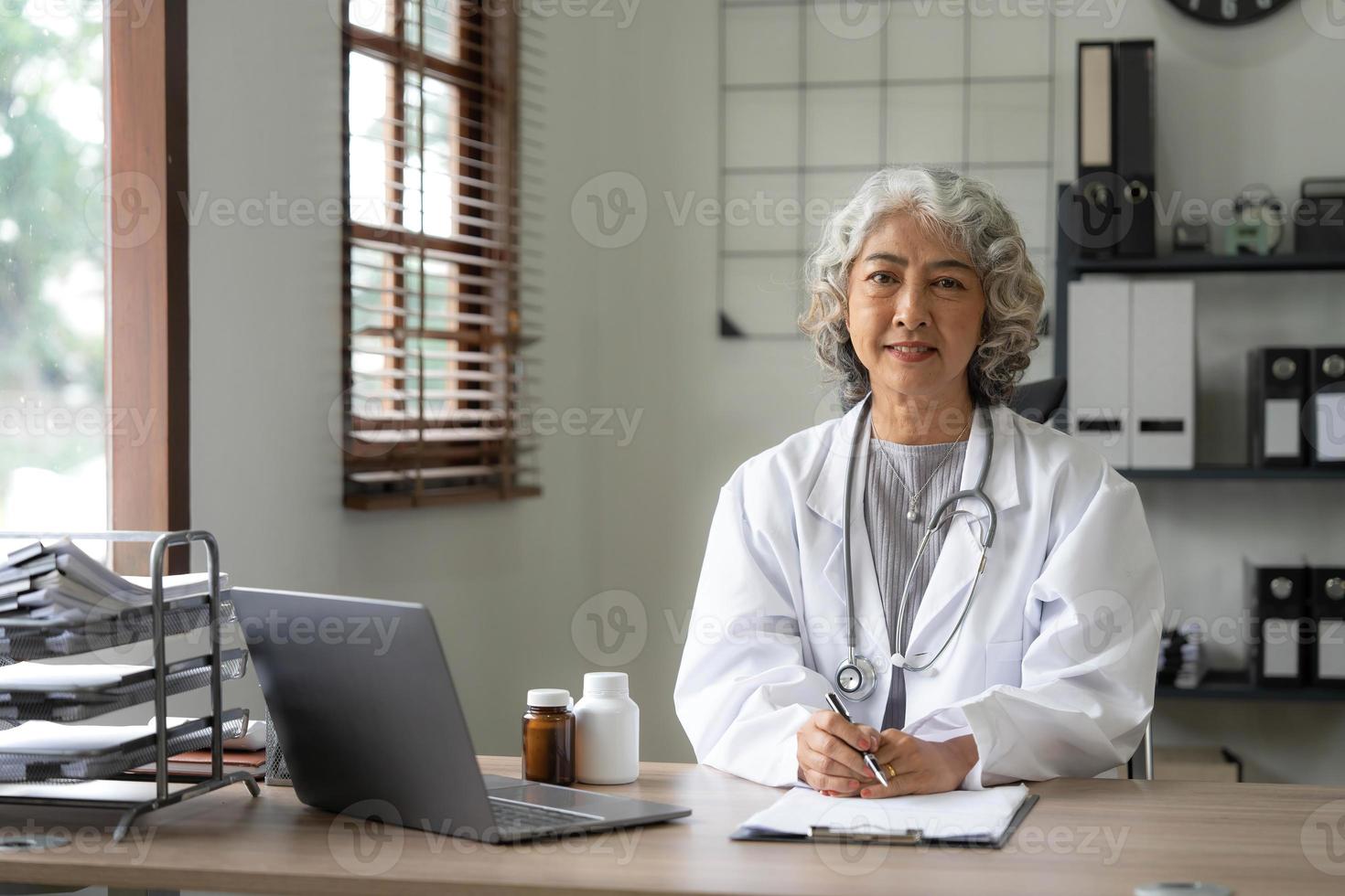 Portrait of Asian doctor working at her table in clinic photo