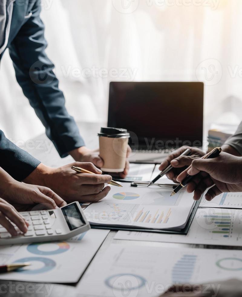 Business People Meeting using laptop computer,calculator,notebook,stock market chart paper for analysis Plans to improve quality next month. Conference Discussion Corporate Concept photo
