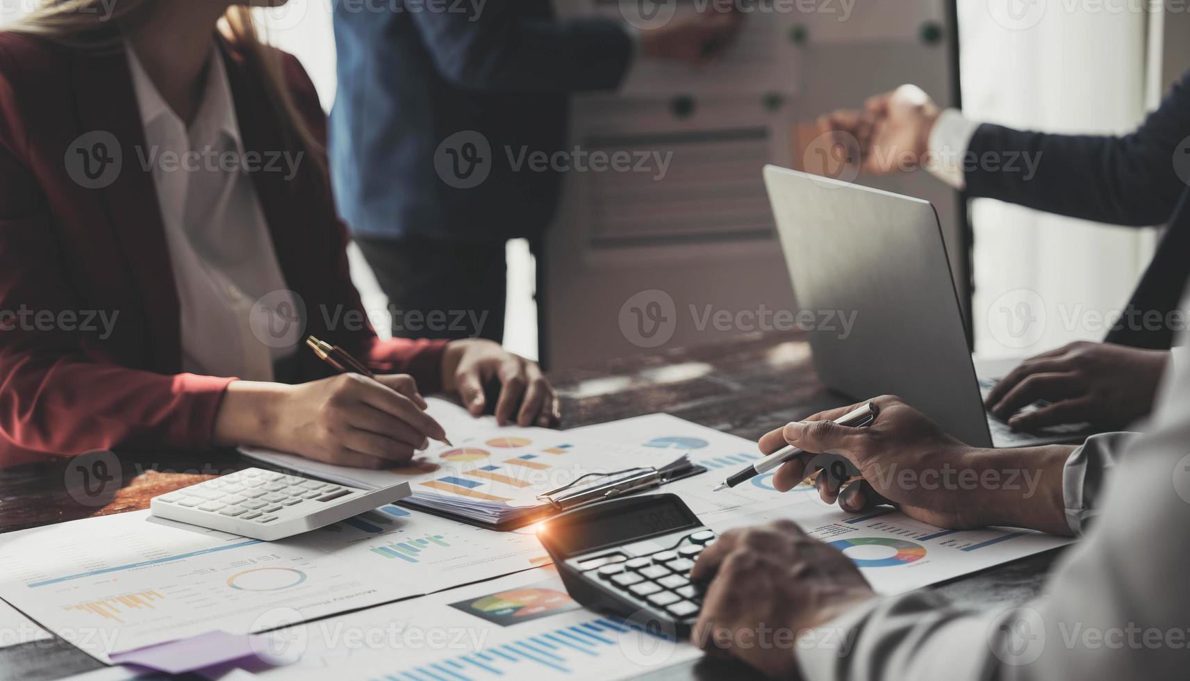 Business People Meeting using laptop computer,calculator,notebook,stock market chart paper for analysis Plans to improve quality next month. Conference Discussion Corporate Concept photo