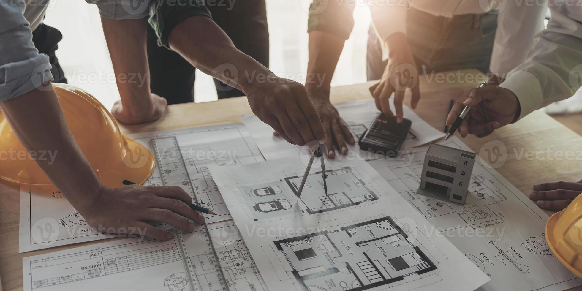 reunión de trabajo en equipo de ingenieros, trabajo de dibujo en la reunión de planos para el trabajo del proyecto con un socio en la construcción de modelos y herramientas de ingeniería en el concepto de sitio de trabajo, construcción y estructura. foto