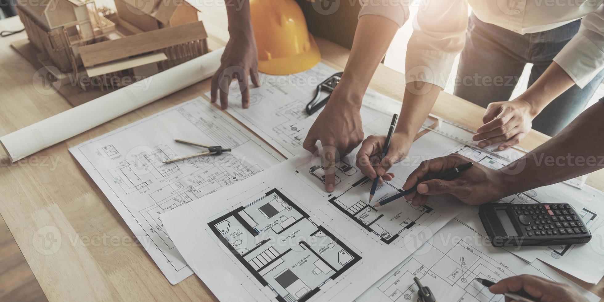 reunión de trabajo en equipo de ingenieros, trabajo de dibujo en la reunión de planos para el trabajo del proyecto con un socio en la construcción de modelos y herramientas de ingeniería en el concepto de sitio de trabajo, construcción y estructura. foto