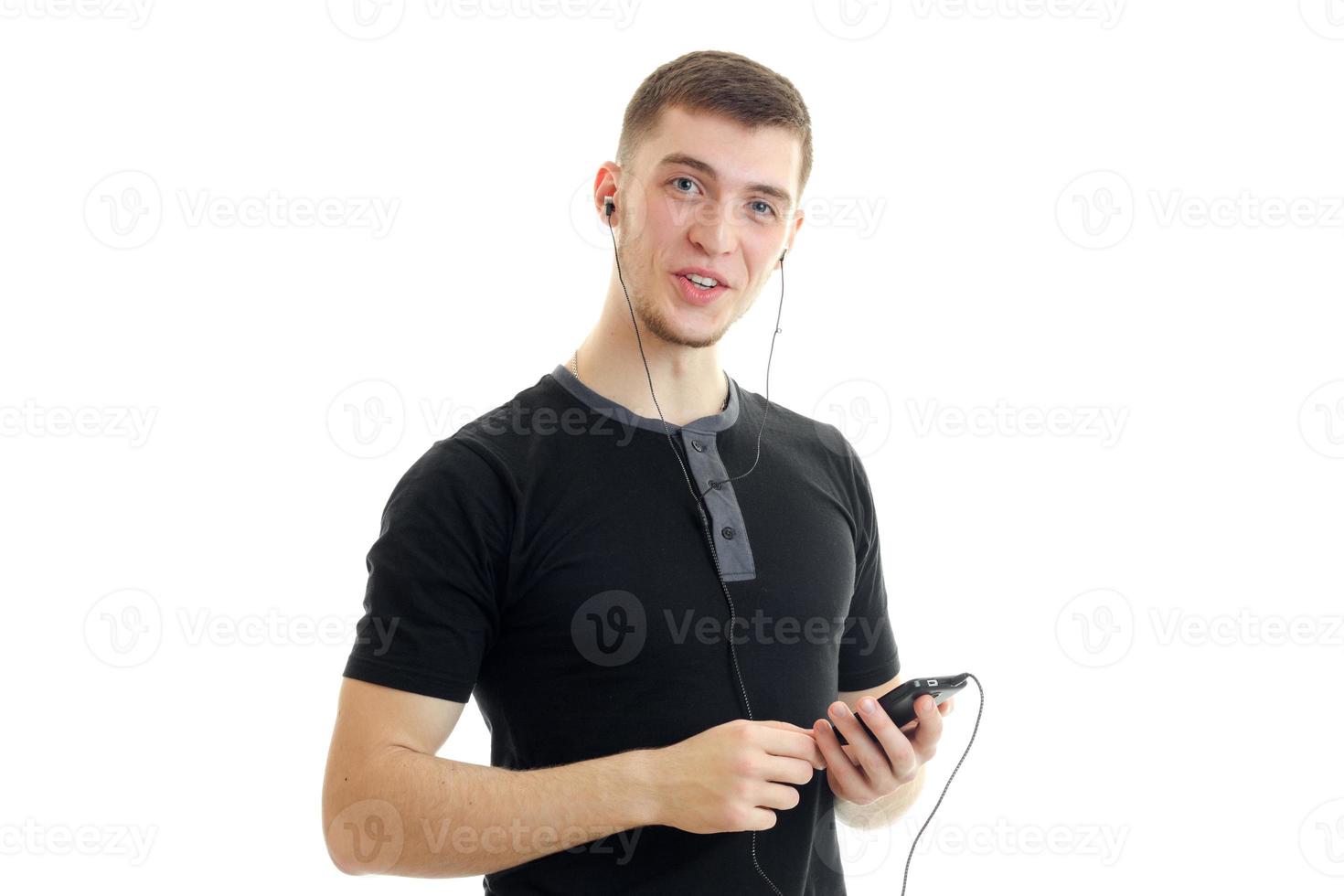 charming young guy in a t-shirt listens to music with headphones photo