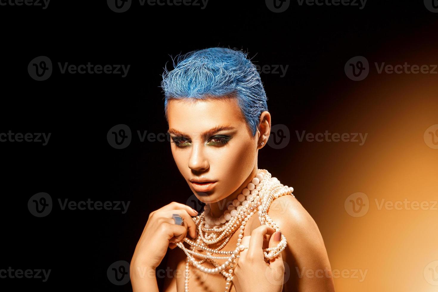 Pearl necklace on a girl with blue hair and beautiful green makeup photo