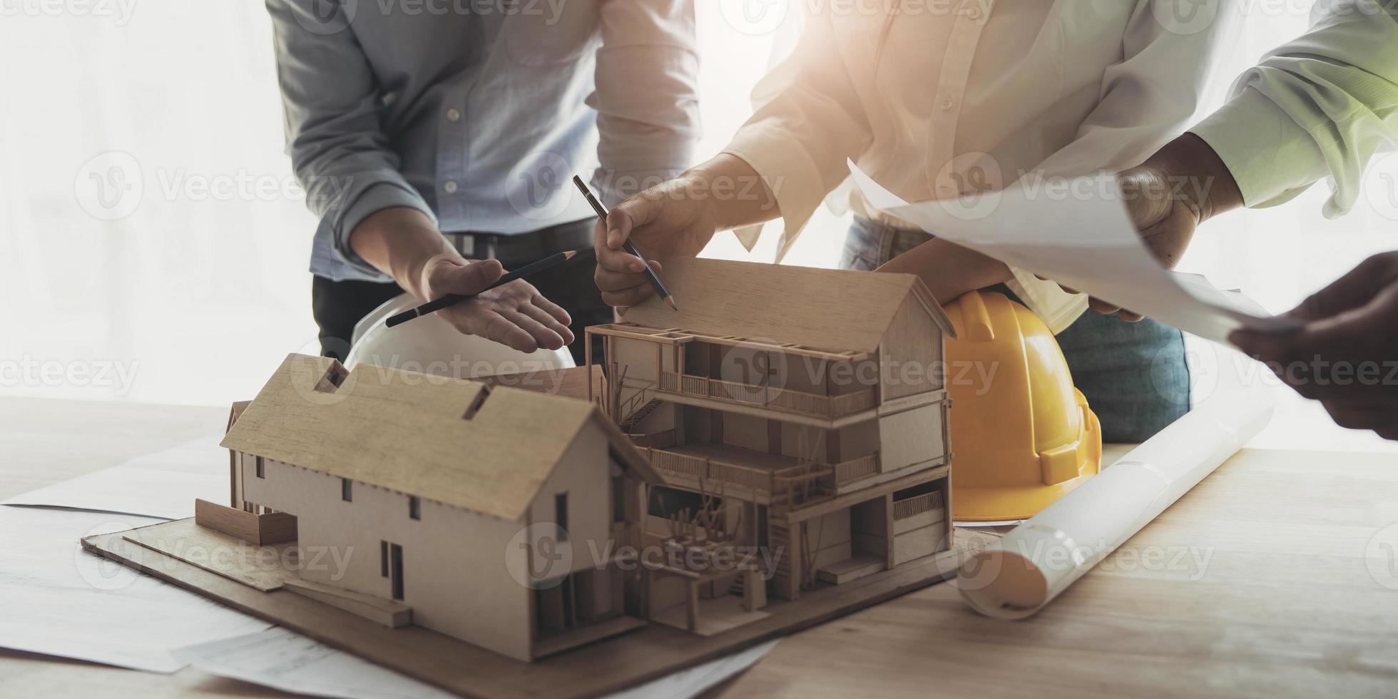 reunión de trabajo en equipo de ingenieros, trabajo de dibujo en la reunión de planos para el trabajo del proyecto con un socio en la construcción de modelos y herramientas de ingeniería en el concepto de sitio de trabajo, construcción y estructura. foto