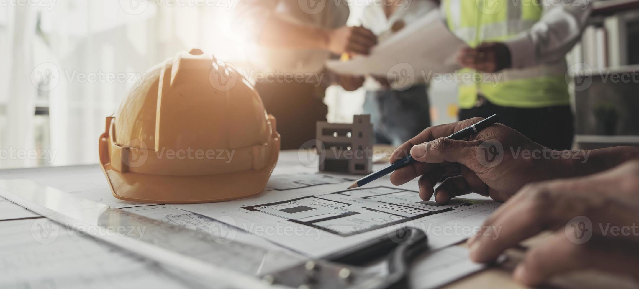 Civil engineer teams meeting working together wear worker helmets hardhat on construction site in modern city. Foreman industry project manager engineer teamwork. Asian industry professional team photo