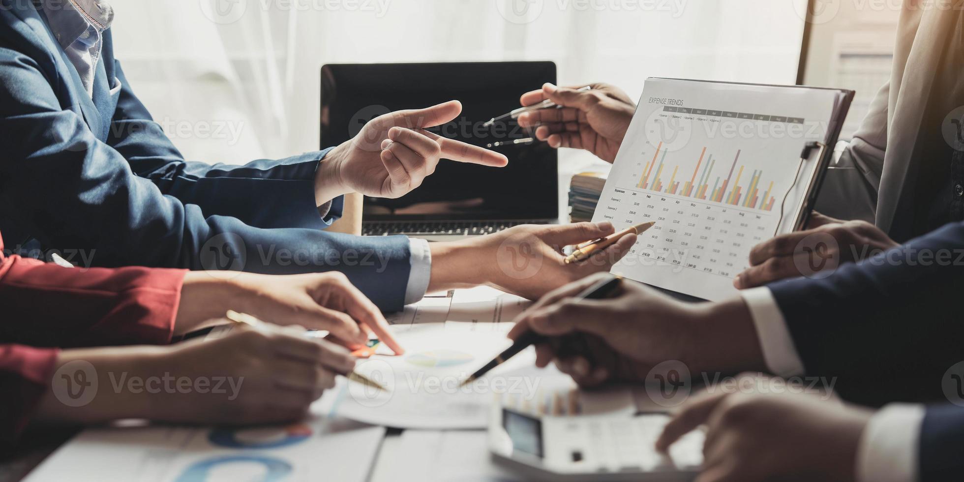 Business People Meeting using laptop computer,calculator,notebook,stock market chart paper for analysis Plans to improve quality next month. Conference Discussion Corporate Concept photo