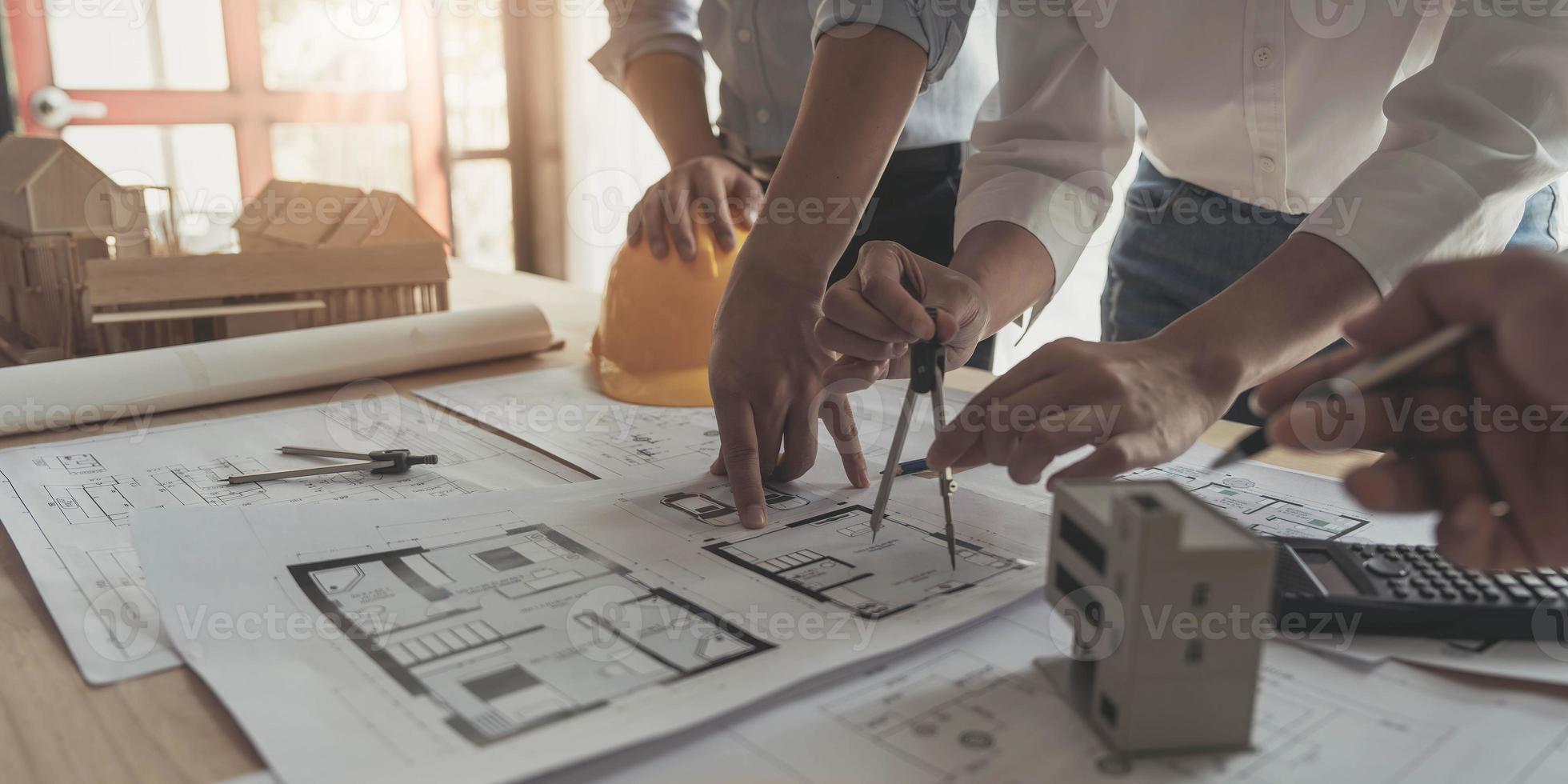 reunión de trabajo en equipo de ingenieros, trabajo de dibujo en la reunión de planos para el trabajo del proyecto con un socio en la construcción de modelos y herramientas de ingeniería en el concepto de sitio de trabajo, construcción y estructura. foto