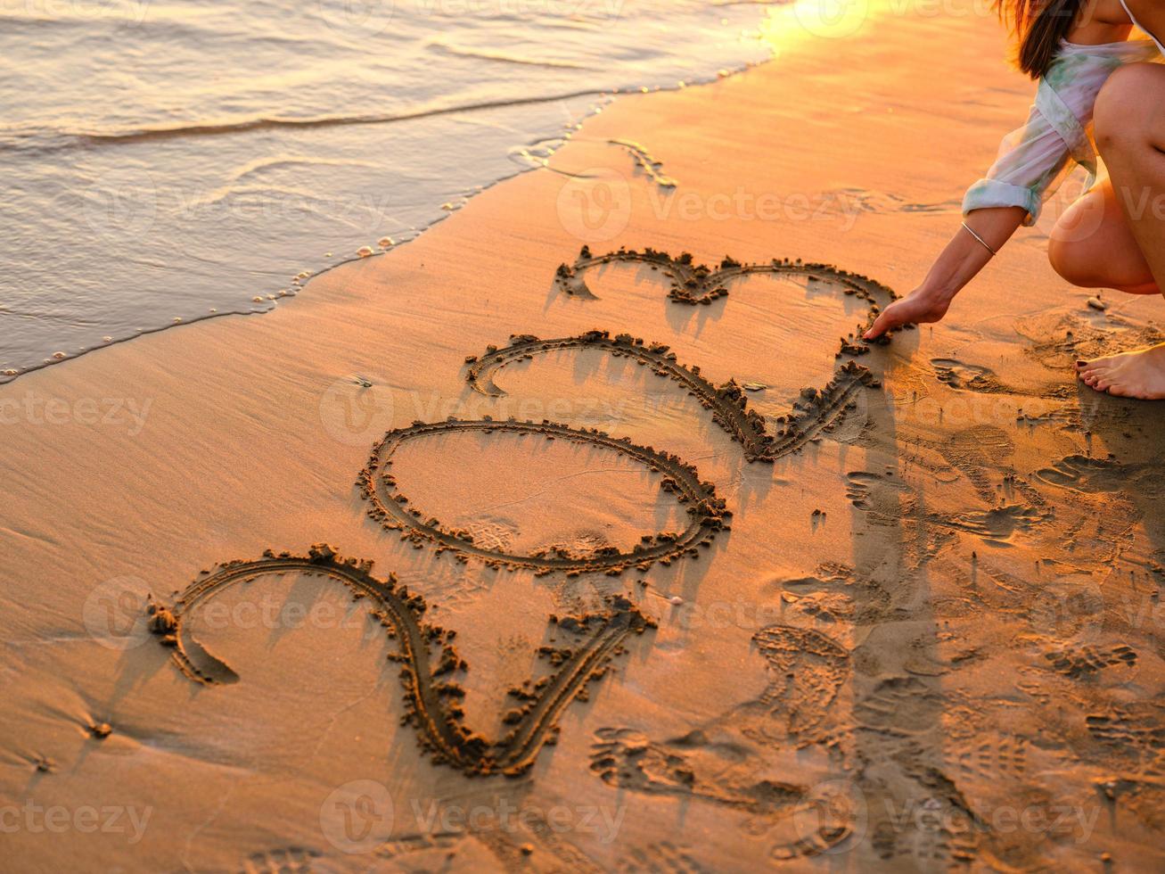 New year concept photo. Numbers 2023 handwritten in the sand surface. Soft sea wave and beach on background. photo