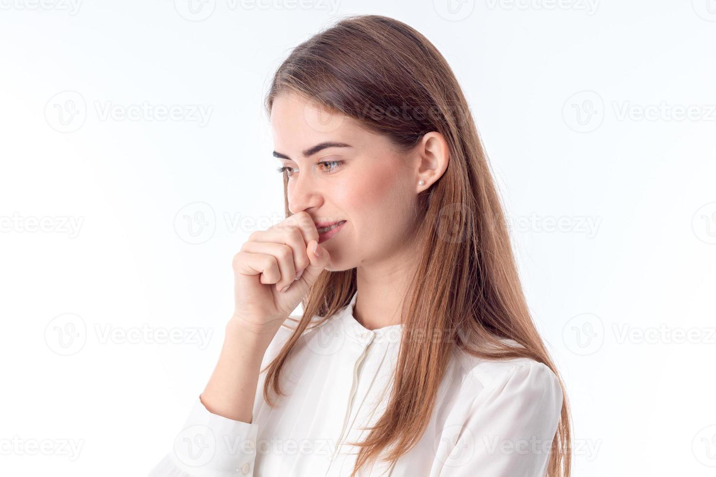 girl is worth turning sideways and holding a fist near the mouth  isolated on  white background photo