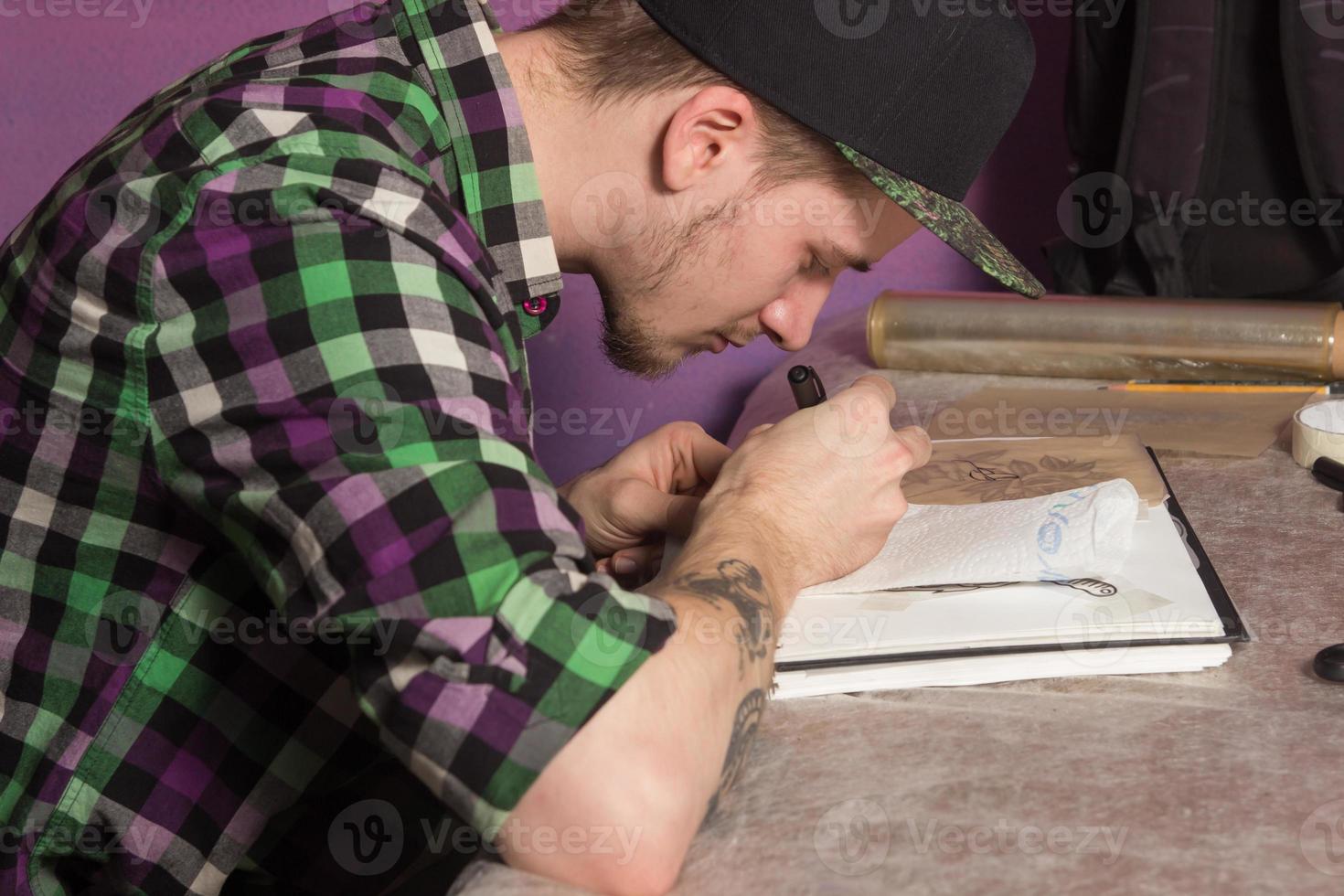 Tatooer is making tatoo photo
